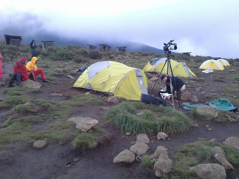 Camp at dusk with filming equipment