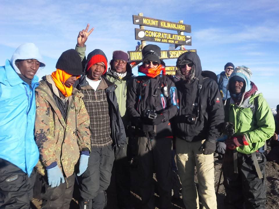 Celebrating at the Kilimanjaro summit sign