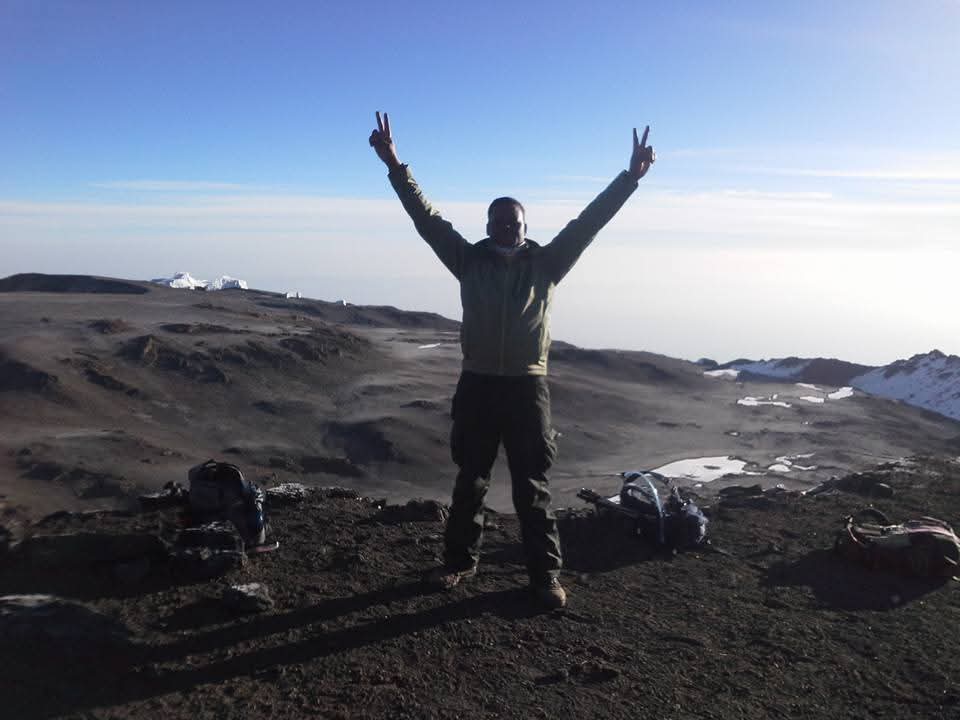 A climber celebrating at the summit crater rim