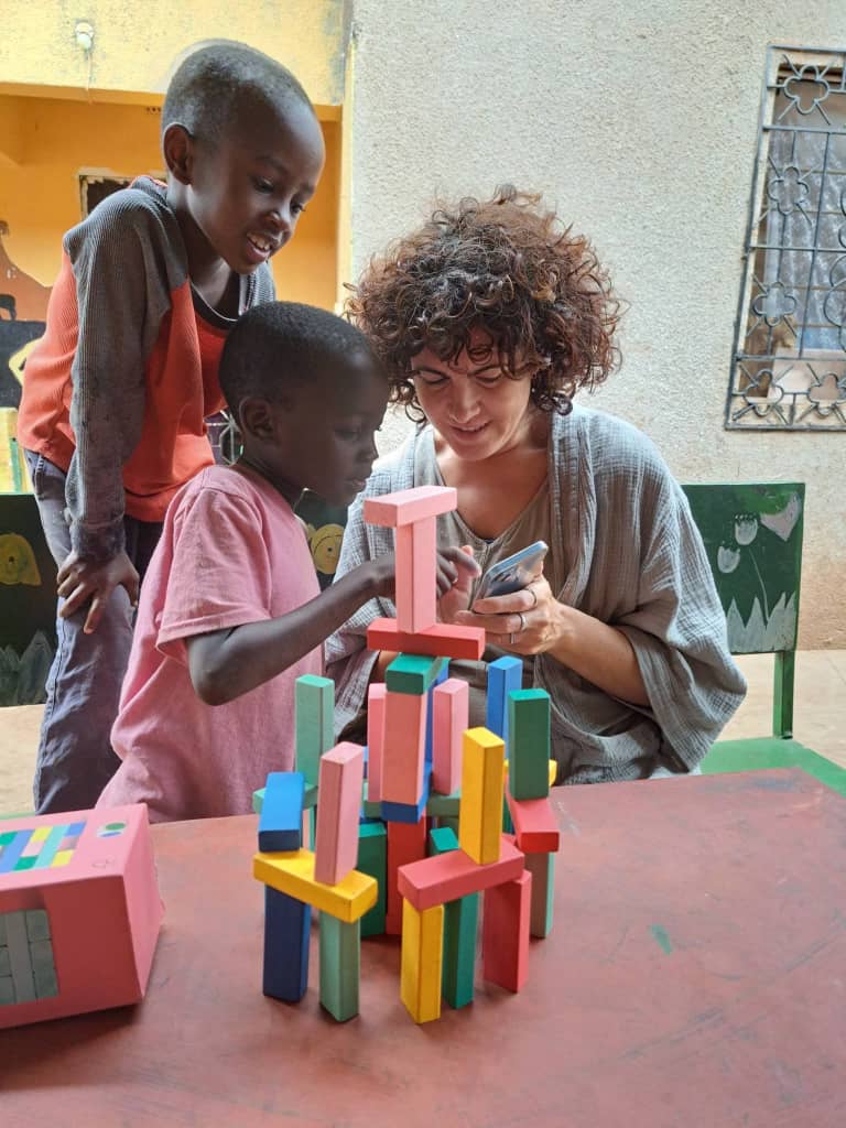 A traveler playing with children at a community center